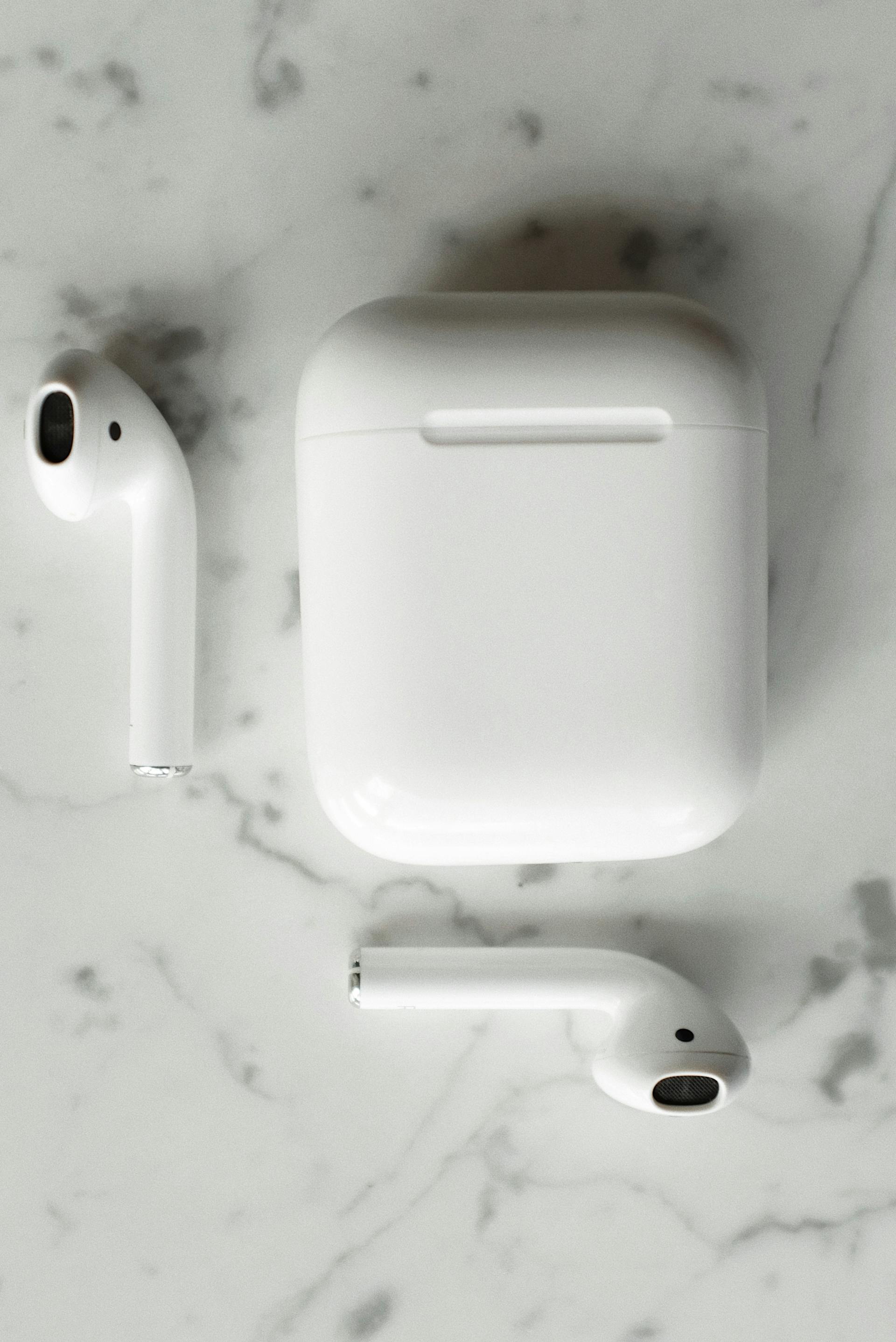 Wireless earbuds resting beside their charging case